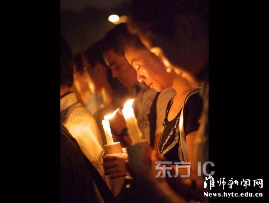 2008年5月20日晚，江苏淮阴师范学院川籍学生自发组织全校师生，在校广场中央，用烛光点亮神州大地，为中国祈福，为中国加油。图为大学生手持蜡烛高唱国歌